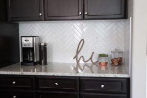 kitchen counter styling with herringbone subway tile backsplash