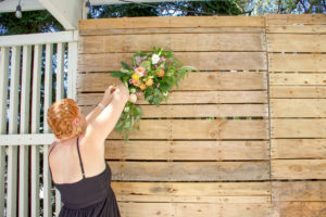 Heather placing florals on pallet wall