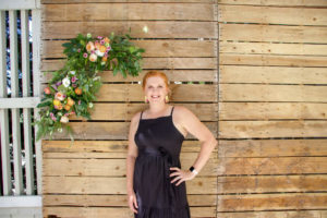 Heather in front of pallet wall photo backdrop