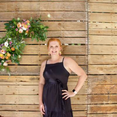 Heather in front of pallet wall photo backdrop