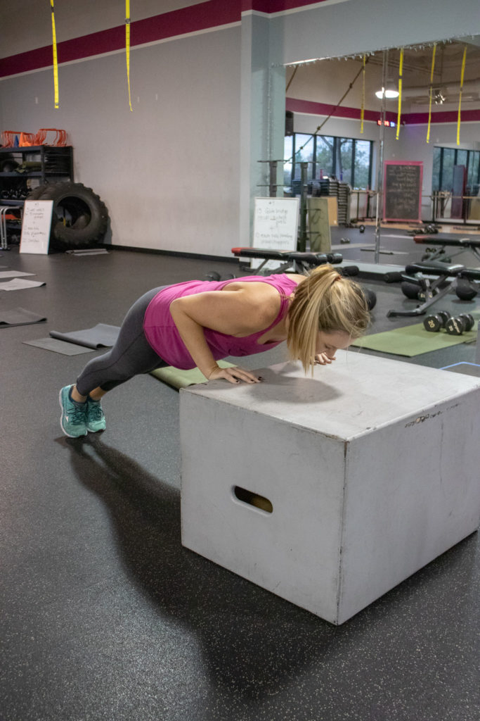 Brittany doing a push up on a box at Kaia Fit