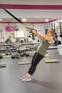 Heather using the TRX straps at Kaia Fit