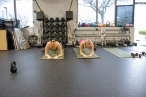 Heather and Brittany doing planks at Kaia Fit
