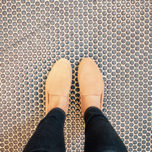 pink loafers on penny tile floor