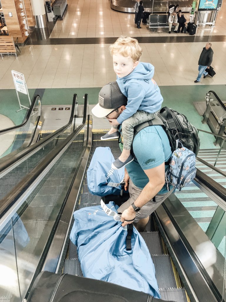 Father carrying luggage and son