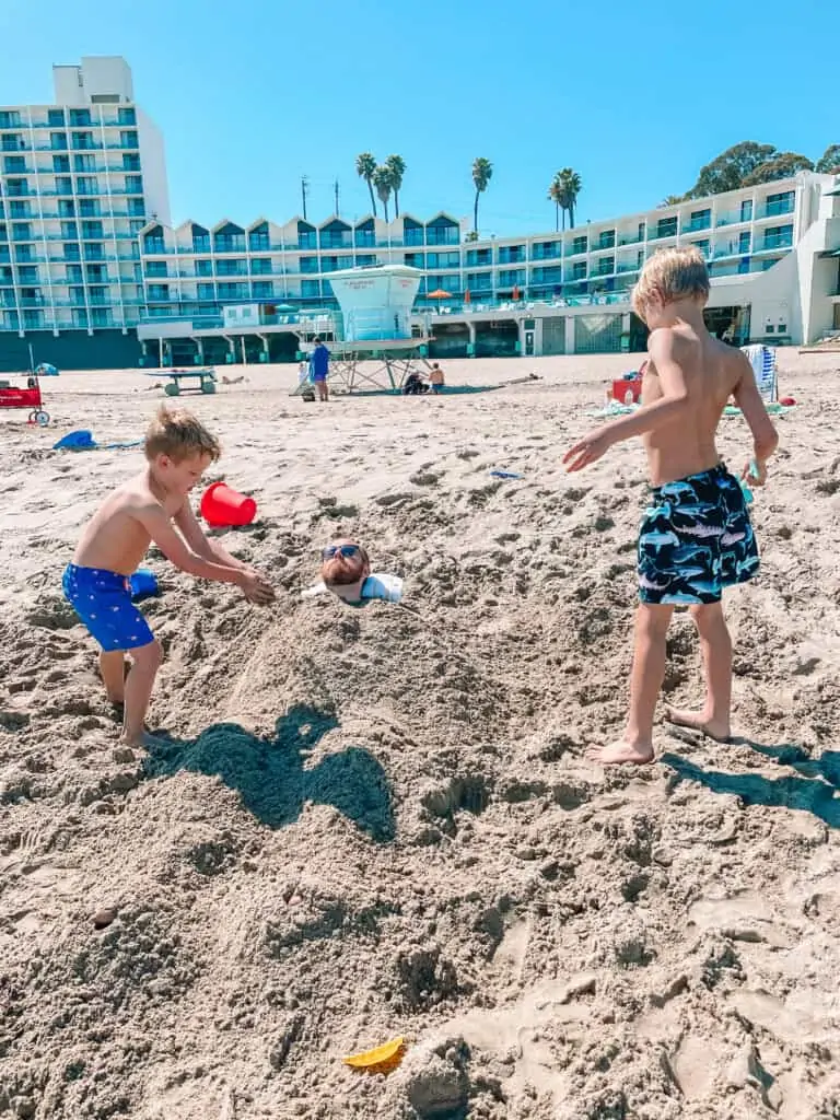 kids burying their dad in the sand